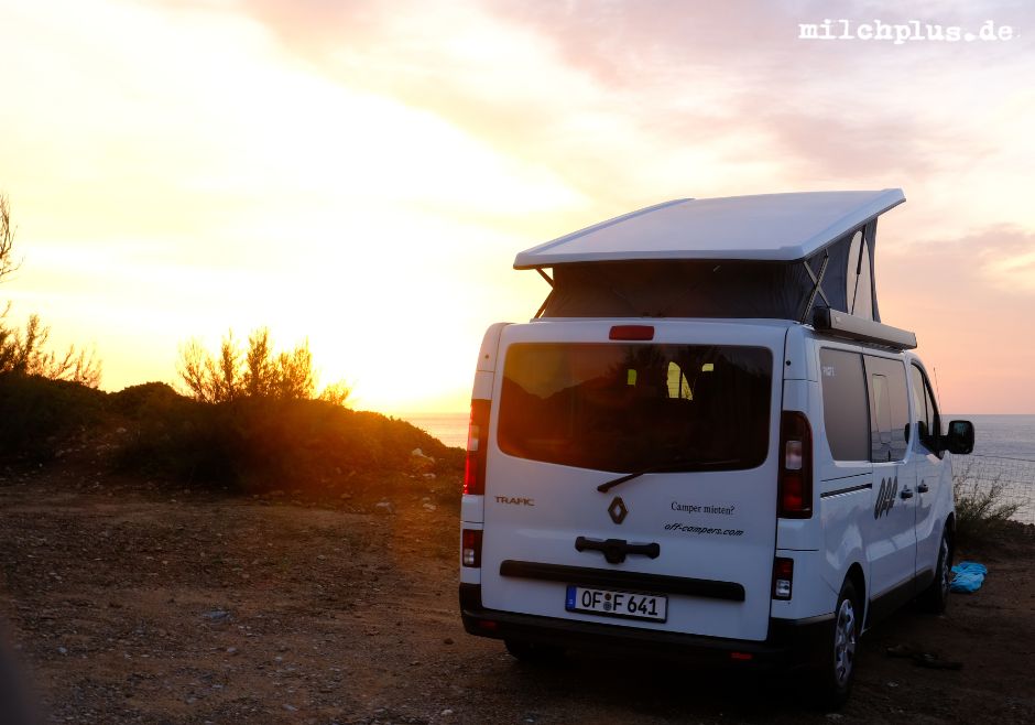 Ein Camper steht vor einem Sonnenuntergang auf einem Stellplatz an Sardiniens Westküste