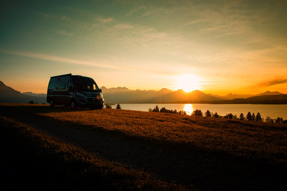 Kiwi-Camper Titelbild mit Camper vor Sonnenuntergang