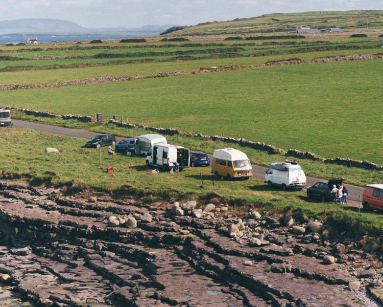 Wohnen im Wohnmobil: Viele Camper an einem Strandparkplatz