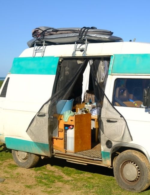 Wohnen im Wohnmobil: Ein VW Bus steht an einem Strand in Portugal
