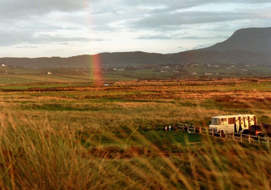Wohnen im Wohnmobil: Ein Camper auf einem irischen Parkplatz mit Regenbogen