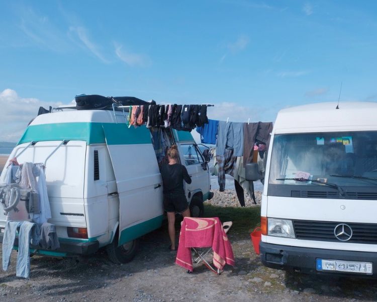 Wohnen im Wohnmobil: Zwei Camper mit Wäsche zwischen den Fahrzeugen