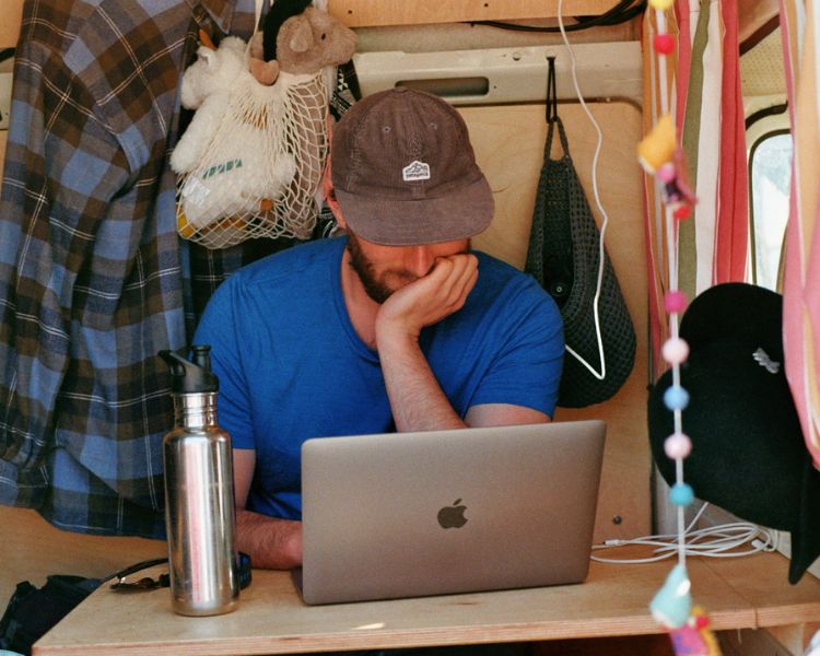 Wohnmobil Packliste: Ein Journalist am Laptop im Camper