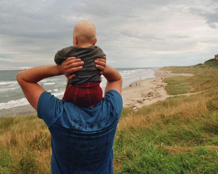 Wohnmobil Packliste: Vater und Tochter gucken aufs Meer und tragen Wollklamotten